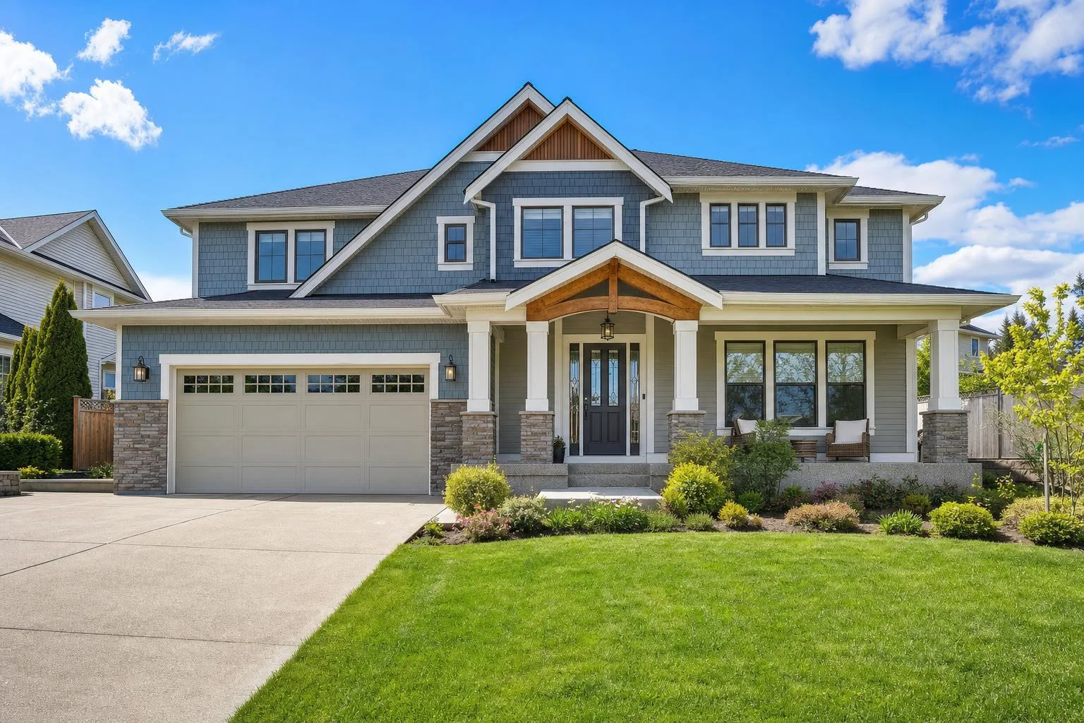 A home exterior with a blue sky and a lush green front lawn.